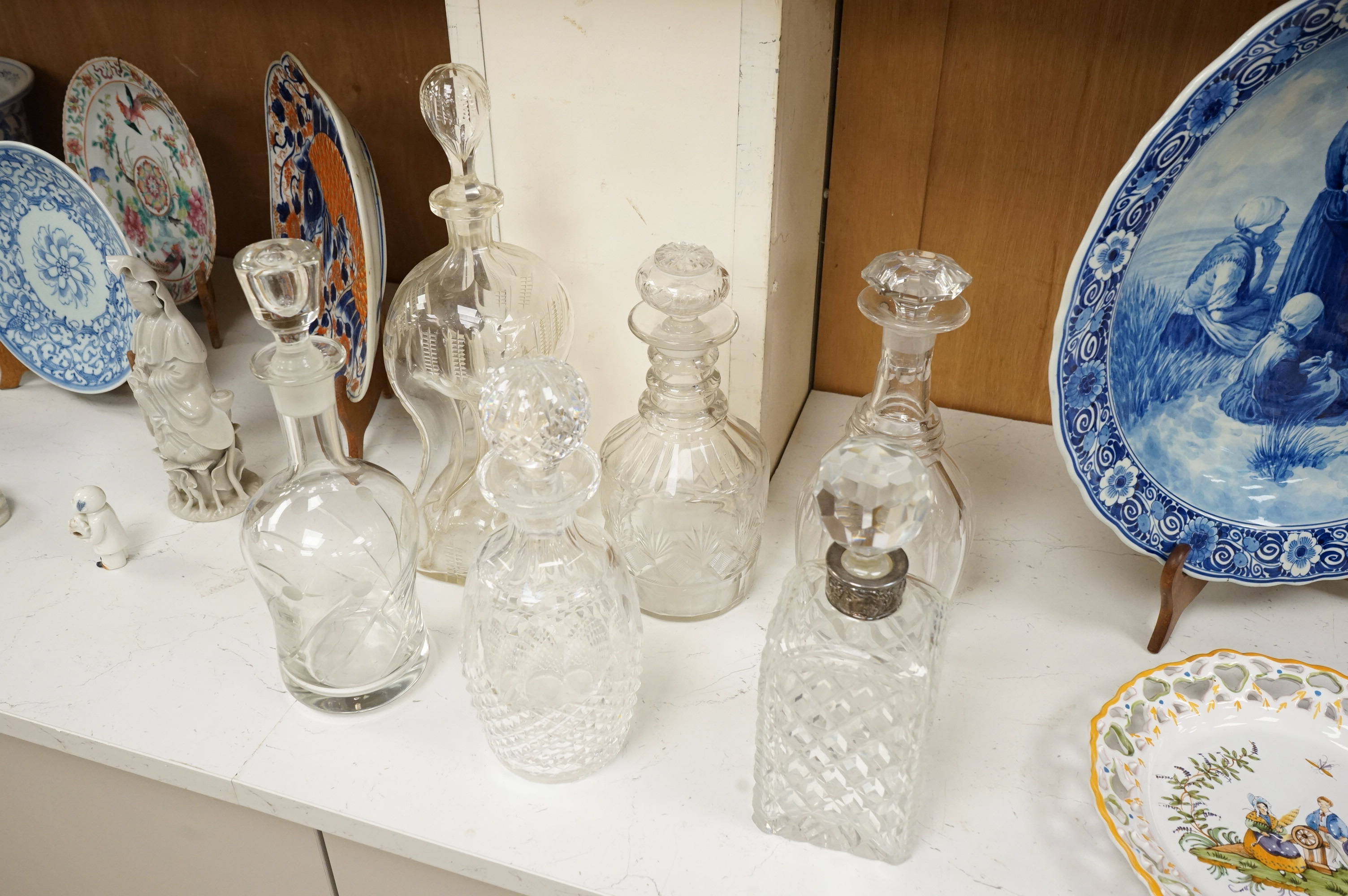 Six 19th century and later cut glass decanters and stoppers, one with white metal acorn design collar, largest 37cm high